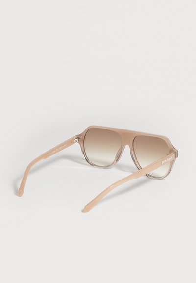 Lunettes de soleil rectangulaires beiges translucides avec verres marron dégradés et logo "Palm Angels" sur la branche, posées sur une surface blanche.