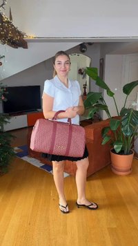 Ροζ τσάντα duffel με δύο λαβές και ασημένιες μεταλλικές λεπτομέρειες, με γεωμετρικό σχέδιο και αντιθετικές πιο σκούρες ρίγες.