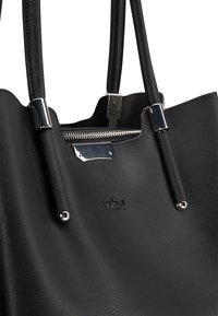 Sac fourre-tout en cuir noir avec finition texturée, accents en matériel argenté et fermeture  éclair visible. Présente un logo de marque embossé à l'avant.