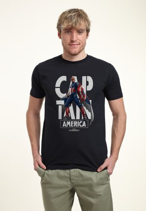 Sort bomulds t-shirt med en illustration af en superhelt med et skjold, tekst der lyder "CAPTAIN AMERICA", og et rektangulært logo nederst.