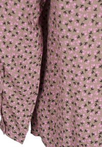 Blumengemusterter Stoff in Beige mit kleinen rosa Blumen und schwarzen Stängeln. Leichtes, strukturiertes Material mit lockerer Passform.