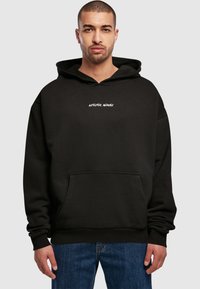 Schwarzer Kapuzenpullover mit lockerer Passform, ausgestattet mit einer Kängurutasche und weißem eingesticktem "Artistic Minds"-Text auf der Brust.