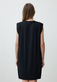 Schwarzes ärmelloses Kleid aus glatter Stoff, mit lockerer Passform und rundem Ausschnitt, geradem Saum und subtilen seitlichen Schlitzen.