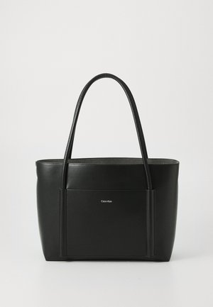 Borsa a tote nera in pelle con due manici lunghi, forma strutturata e tasca frontale. Presenta un piccolo logo bianco sul davanti.