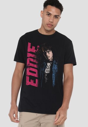 Schwarzes Baumwoll-T-Shirt mit einem grafischen Aufdruck einer Figur in einer Jeansjacke und dem Namen "EDIE" in pinkem Text. Kurze Ärmel, Rundhalsausschnitt.