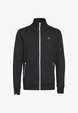 Fekete, cipzáros dzseki álló gallérral. Jellemzői a lapos varrások, két oldalsó zseb cipzárral és egy kis logó a mellrészen.