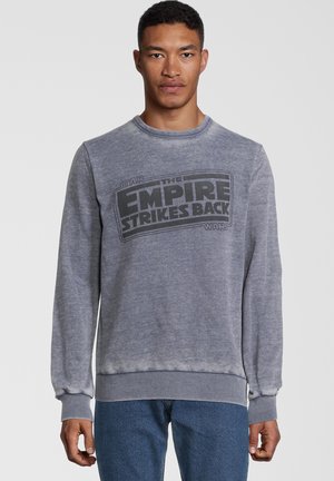 Felpa grigia con collo a giro, maniche lunghe e una stampa grafica che recita "L'IMPERO COLPISCE ANCORA" di Star Wars sulla parte anteriore.