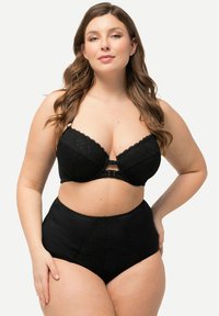 Reggiseno in pizzo nero con ferretto e chiusura frontale, abbinato a slip neri a vita alta con dettagli in pizzo e tessuto liscio.