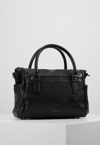 Sac à main en cuir noir avec un motif floral texturé, deux poignées et une fermeture éclair. Comprend une poche latérale et un détail de marque.