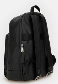 Zaino nero realizzato in materiale testurizzato, dotato di spallacci doppi, maniglia superiore e cerniera argentata con dettaglio del marchio. Design minimalista.