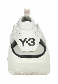 Sneakers Y-3 bianche con una toma superiore testurizzata, accenti neri, un colletto imbottito e un logo distintivo sul tallone.