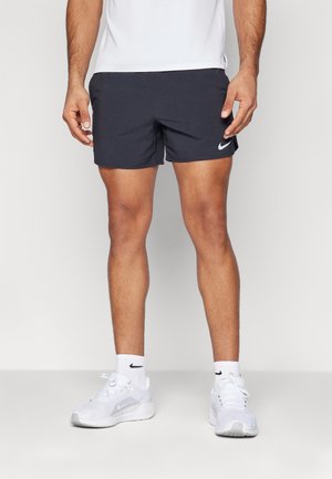 Granatowe spodenki kąpielowe Nike z elastycznym pasem, białym logo Nike po boku oraz lekkim, szybkoschnącym materiałem.