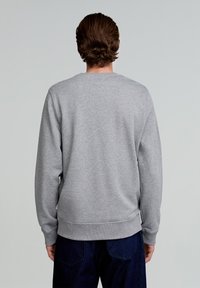 Grauer Rundhalsausschnitt-Sweatshirt mit langen Ärmeln, gerippten Bündchen und Saum. Hergestellt aus weichem Stoff, der eine glatte, schlichte Textur zeigt.