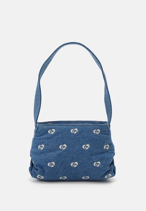 Blå denim skuldertaske med bred rem, dekoreret med et gentaget hvidt abstrakt mønster på stoffet.