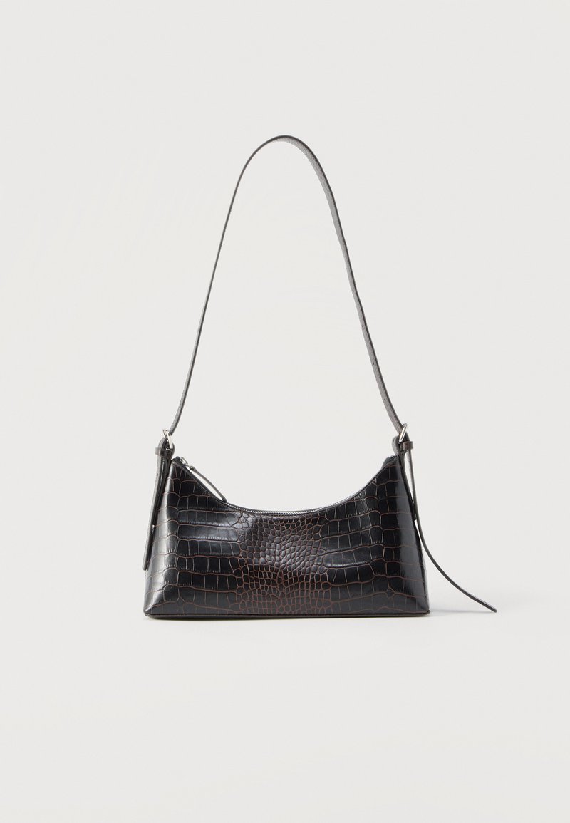 Μαύρη τσάντα ώμου με υφή κροκοδείλου, κλείσιμο με φερμουάρ και μακρύ λεπτό λουρί, παρουσιάζεται σε λευκό φόντο.