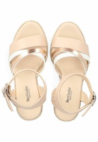Sandali espadrilles beige con suola in juta, caratterizzati da tre ampie cinghie in beige, bianco e con dettagli metallici. Include una cinghia regolabile alla caviglia.