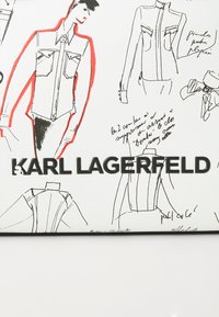 White textured surface featuring black line drawings of fashion designs with red accents. The name "KARL LAGERFELD" is prominently displayed.