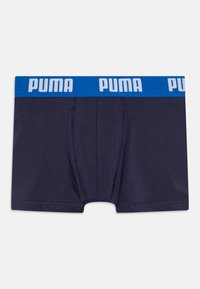 Mornarski bokserice od mekog materijala s plavim elastičnim pojasom na kojem piše "PUMA" bijelim slovima. Prednji dio uključuje horizontalni šav.