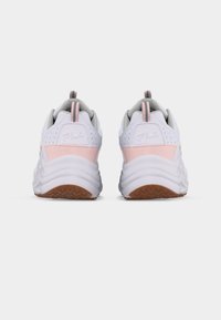 Ζευγάρι από λευκά και ανοιχτόροζ παπούτσια FILA, εμφανιζόμενα από πίσω με παχιές λευκές σόλες και καφέ υφασμένες εξωτερικές σόλες σε απλό φόντο.