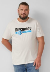 Ecrufarbenes Baumwoll-T-Shirt mit schwarzem und blauem "Discovery Channel"-Logo und Globusgrafik. Kurzärmlig und im Rundhalsdesign.