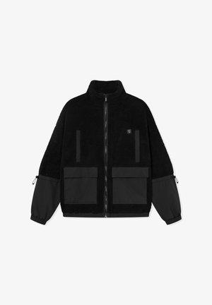 Black fleece jacket with a high collar, zip closure, and two front patch pockets. Features contrasting black fabric sleeves and adjustable cuffs.