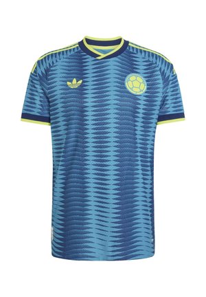 Niebieska koszulka piłkarska z ciemnoniebieskim wzorem fal, żółtym kołnierzem i wykończeniem rękawów, logo Adidas oraz emblematem Kolumbijskiej Federacji Piłkarskiej.