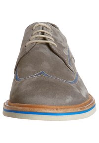 Scarpa da dress in camoscio grigio da uomo con lacci beige, dettagli in cucitura blu e suola marrone con una striscia blu, vista di fronte.