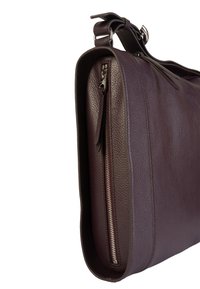 Bolso de hombro de cuero morado oscuro con una superficie texturizada, bolsillo con cremallera lateral y una correa ajustable. Diseño elegante y minimalista.