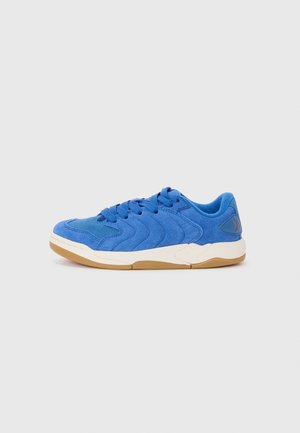 Blaue Wildledersneaker mit strukturiertem wellenförmigem Design, Schnürung vorne, gepolstertem Kragen und hellbraunem Gummi-Außensohle. Rotes Akzentlogo an der Ferse.