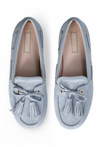Mocassins en daim bleu clair avec un bout arrondi, un détail de pampille décorative et des œillets en métal pour les lacets. Doublure intérieure lisse.