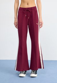 Bordeaux brede sweatpants med en tekstureret finish, der har en cremefarvet side-stribe og guld snøre detaljer. Sæt sammen med sorte sneakers.