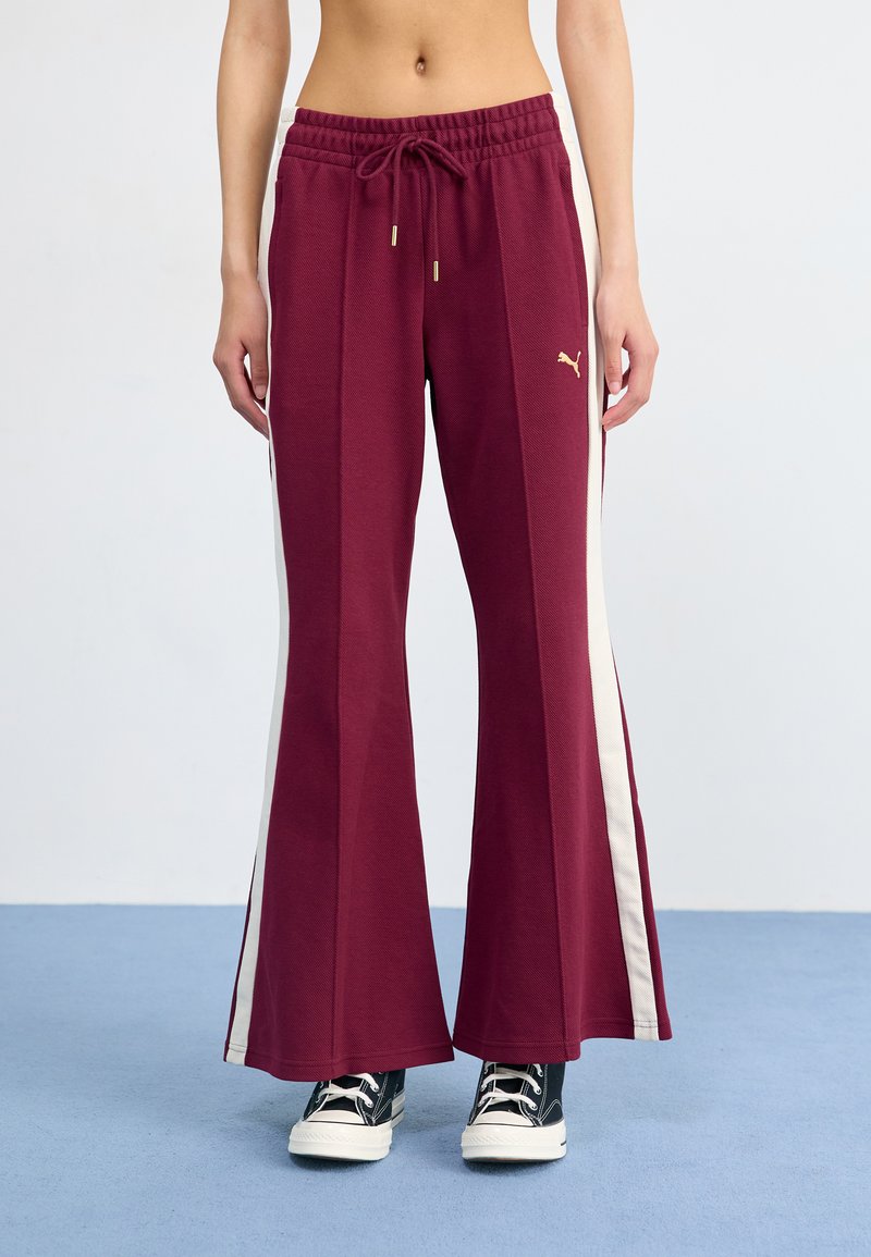 Bordeaux brede sweatpants med en tekstureret finish, der har en cremefarvet side-stribe og guld snøre detaljer. Sæt sammen med sorte sneakers.