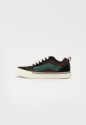 Sneaker neri e marroni con accenti color turchese, dotati di una tomaia in tela, lacci bianchi, suola in gomma e dettagli di cucitura in contrasto.