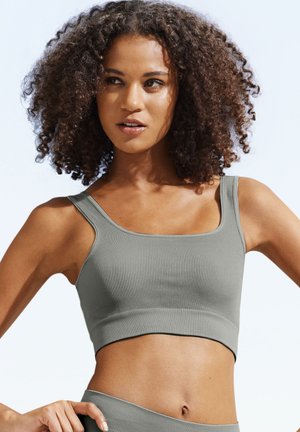 Ribbed sports crop top in soft green, featuring a square neckline and wide shoulder straps, designed with a fitted silhouette.