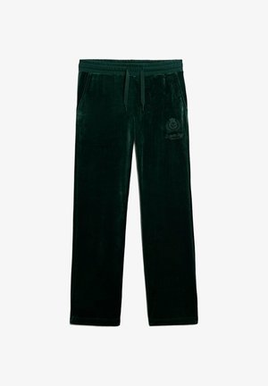 Pantaloni della tuta in velluto verde scuro con vita elastica, cordoncino, tasche laterali e dettaglio del logo ricamato sulla coscia sinistra.