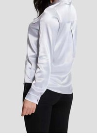 Satin white long-sleeve shirt with a back vent, buttoned cuffs, and a smooth texture. Features a classic collar and subtle sheen.