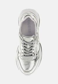 Zilveren metalen sneaker met een gladde textuur, voorzien van platte veters, een gevoerde tong en een logo dat op de zijkant is geperst. Ronde neus en dikke zool.
