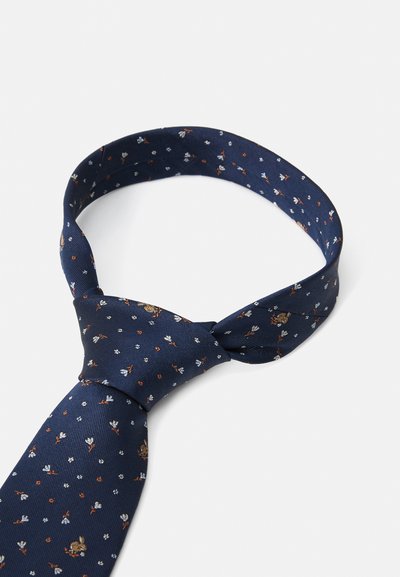 Mørkeblå slips laget av silke med en teksturert finish, med et blomstermønster i hvitt og oransje. Stylet i en klassisk knute.