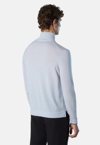 Maglione a collo alto di colore azzurro chiaro, lavorato a maglia, con maniche lunghe, colletto a coste e orlo a coste, caratterizzato da una texture liscia e un design aderente.
