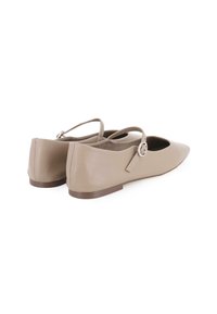 Bailarinas beige con punta afilada, hechas de cuero suave, que cuentan con una delicada correa en el tobillo con un detalle de hebilla circular.