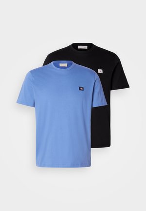 Δύο βαμβακερά T-shirts, ένα ανοιχτό μπλε και ένα μαύρο, με στρογγυλά γιακά και μικρές λογότυπες ραφές στο στήθος. Λαμπερή υφή.