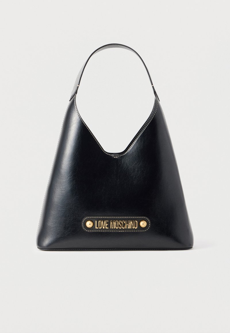 Sac à main trapèze en cuir noir avec une anse unique et une plaque dorée "Love Moschino" sur le devant, présenté sur un fond blanc.