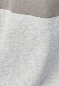 Tela de algodón gris y gris claro, con una textura suave y un sutil patrón jaspeado, que presenta un diseño de bloques de color en diagonal.