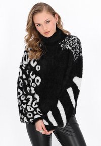 Pulover fuzzy alb-negru cu modele amestecate de print cu animale, mâneci lungi, guler înalt și design texturat de tricot.