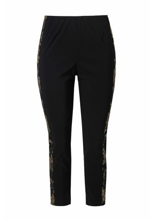 Pantalon noir avec une taille élastique, ornée de broderies florales dorées sur les côtés. Coupe slim avec une longueur cropped. Matière douce.