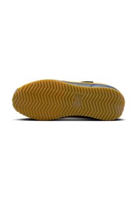 Semelle de sneaker Nike avec un motif en zigzag. Dégradé de couleur du gris foncé au jaune. Texture lisse avec le logo Nike visible.