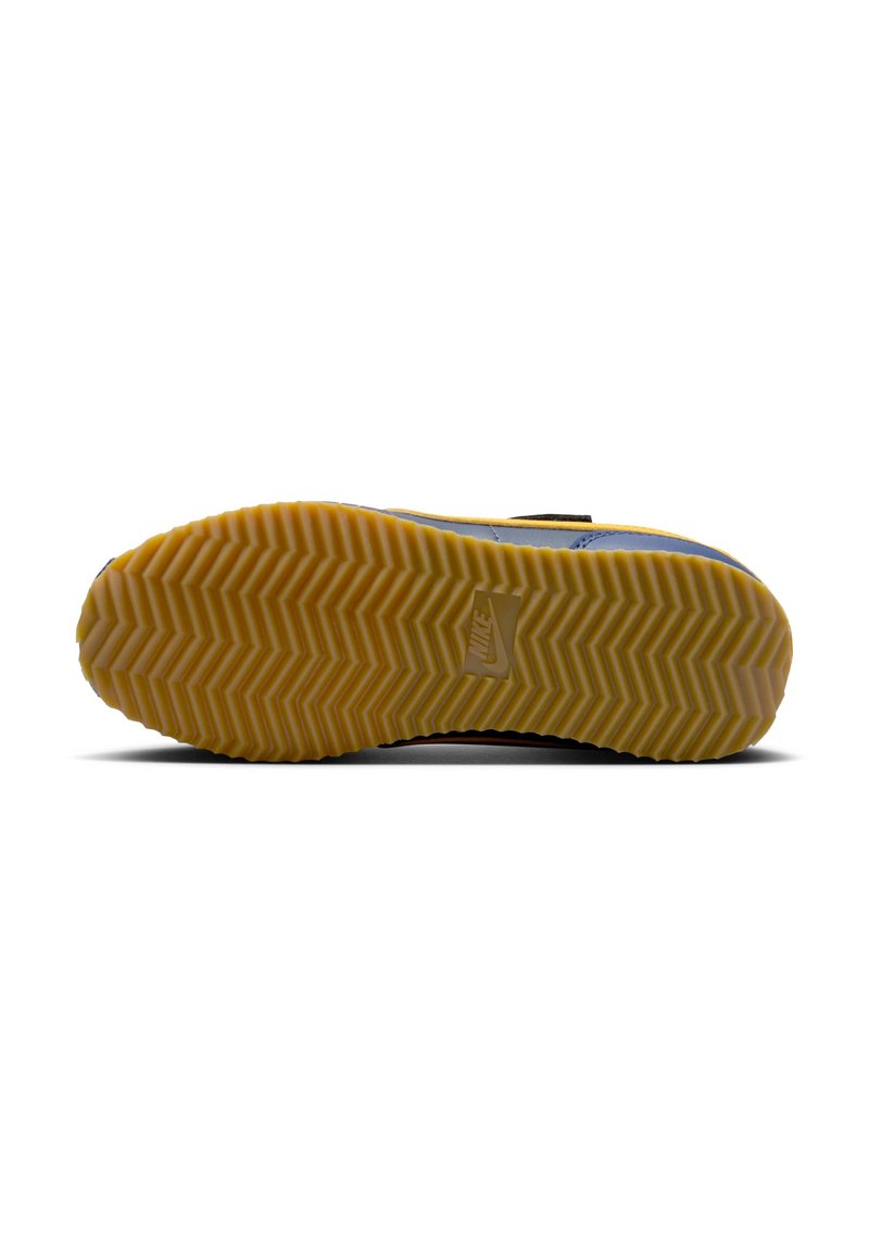 Semelle de sneaker Nike avec un motif en zigzag. Dégradé de couleur du gris foncé au jaune. Texture lisse avec le logo Nike visible.