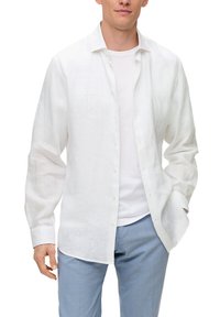 Witte linnen overhemd met een relaxed fit, lange mouwen, knoopsluiting aan de voorkant en een licht gestructureerd oppervlak, gedragen over een wit T-shirt en lichtblauwe broek.
