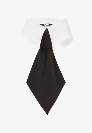 Corbata de etiqueta negra con punta y un cuello blanco estructurado. Textura suave; nudo en el centro. Etiqueta visible bajo el cuello.