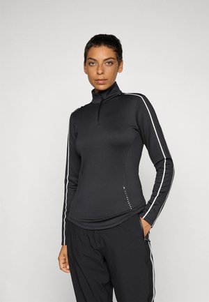 Svart langermet topp med halv-zip krage, med hvite sidestreker og glatt, elastisk stoff. Merkbar logo detalj ved sømmen.